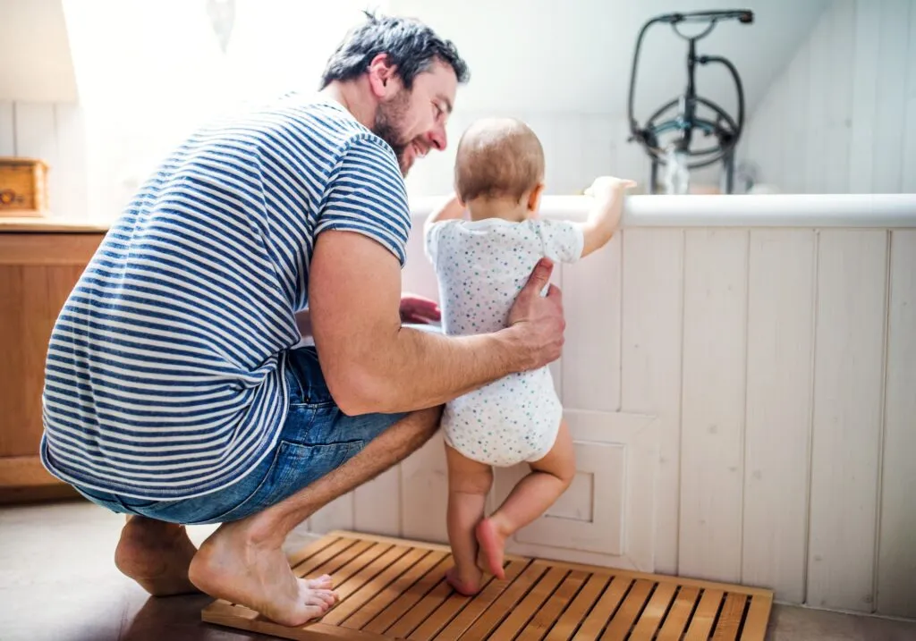 Father and toddler enjoying time together in a bathroom, emphasizing family comfort and home care, relevant to R&A Industries' focus on reliable hot water solutions.