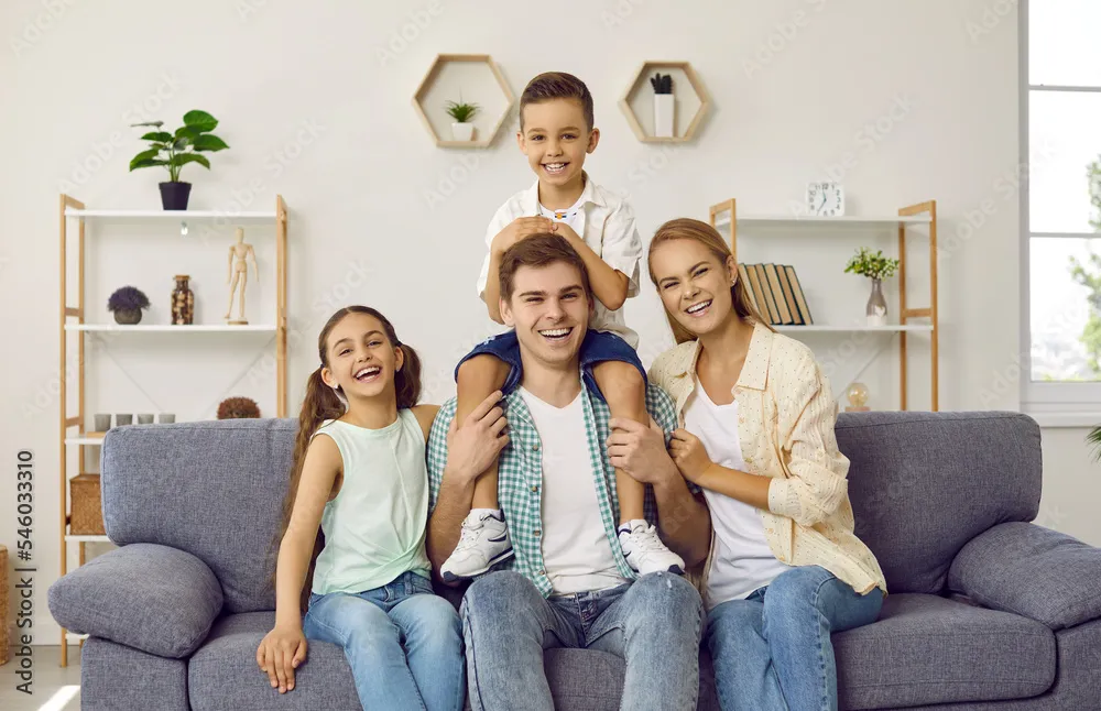 Happy family portrait on sofa. Home electrical panel installation may improve family time in Oviedo, FL.