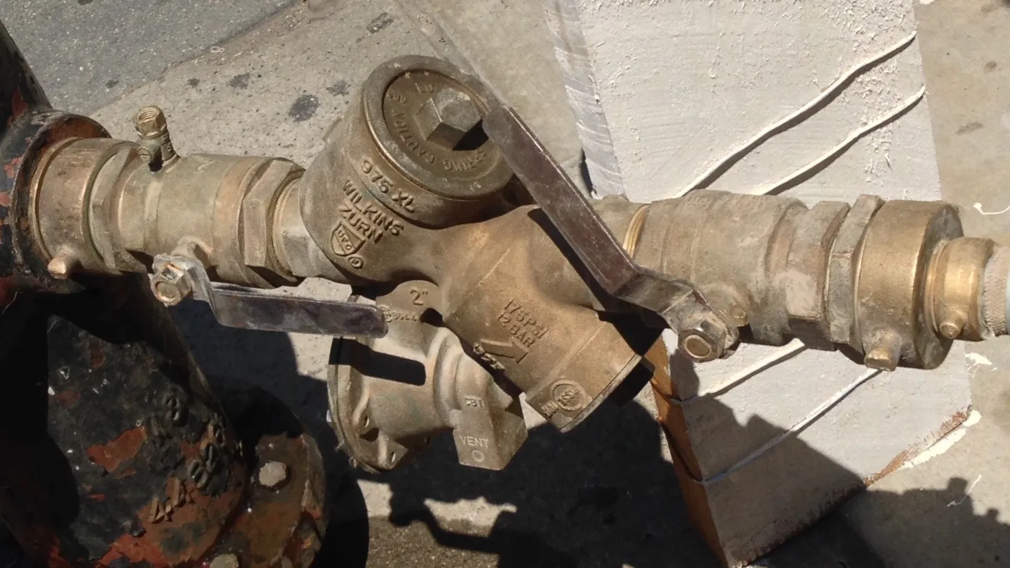 Close-up of a Wilkins Zurn 975XL backflow preventer. Backflow testing is essential for water safety. Ensure your system's integrity today.