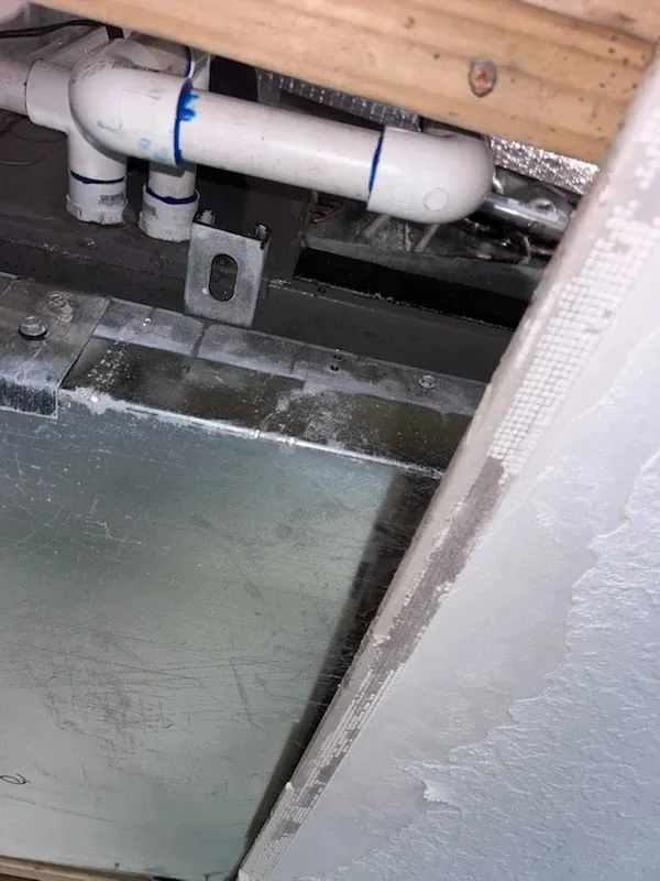 View of plumbing system with PVC pipes and metal ductwork, highlighting potential areas for zoogloea slime growth in Oviedo plumbing.
