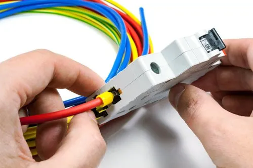 Electrical wiring being installed. Electrician installing wires for whole home rewiring in Oviedo, FL. Circuit breaker with red, blue, and yellow wires.