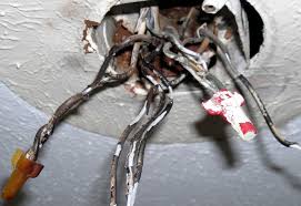 Electrical wiring exposed from a ceiling hole. Home rewiring hazards in Oviedo, FL. Electrical service for old wiring replacement.