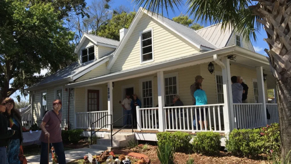 Exterior of a renovated home in Oviedo, FL, with people on the porch. Consider whole home rewiring for safety and modern electrical needs.