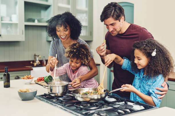 Happy family cooking on a gas stove. Ensure gas leak detection in Oviedo, FL for a safe home. Prevent gas leaks with regular checks.