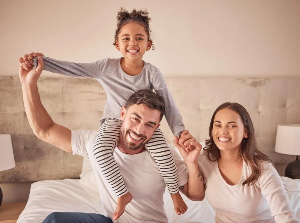 Happy family in Oviedo, FL, enjoying Smart Home Installation benefits with a smiling child on dad's shoulders, creating lasting memories.