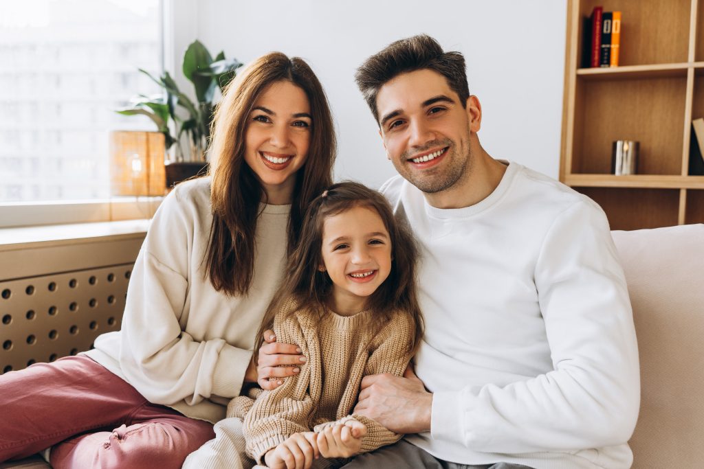 Smiling family portrait showing happiness and unity; consider electrical safety for a secure home environment in Oviedo, FL.